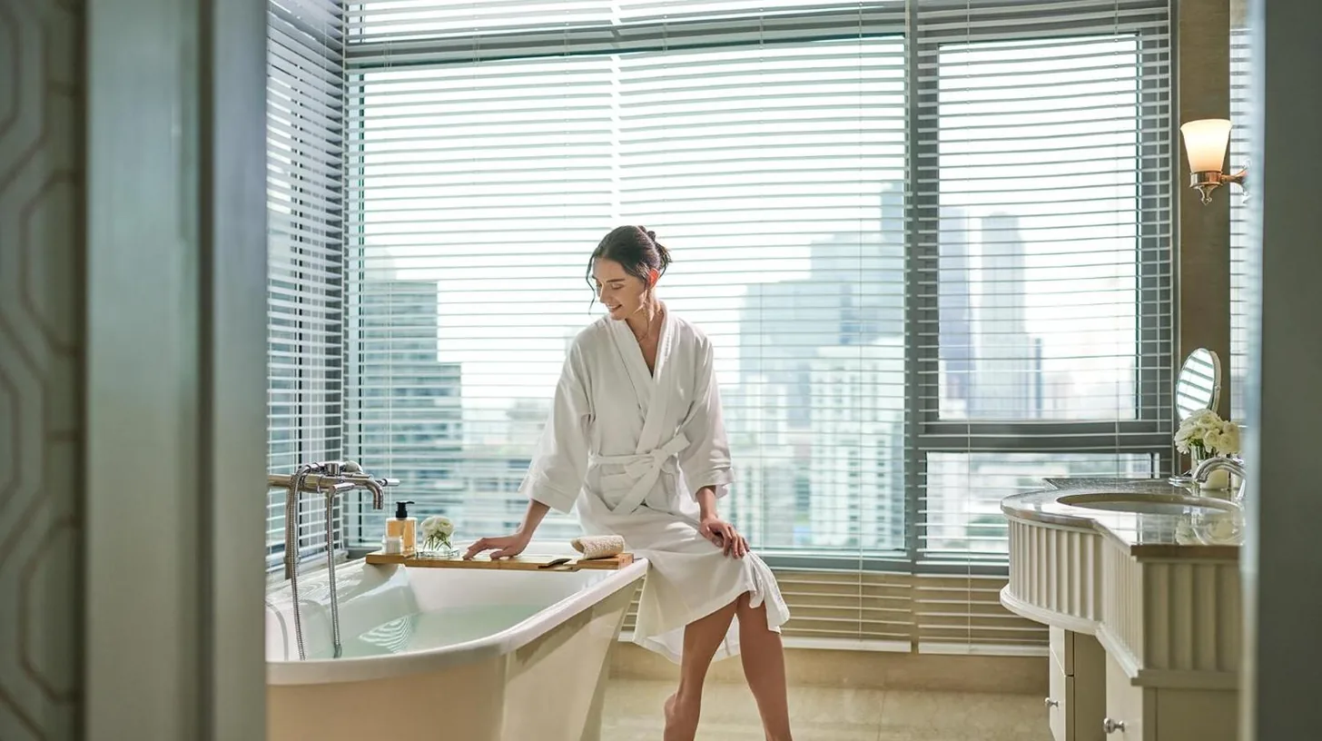 una mujer sentada en una bañera en un baño en Oriental Residence Bangkok en Bangkok