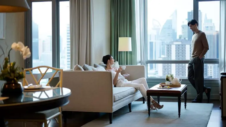 una mujer sentada en un sofá en una sala de estar en Oriental Residence Bangkok en Bangkok