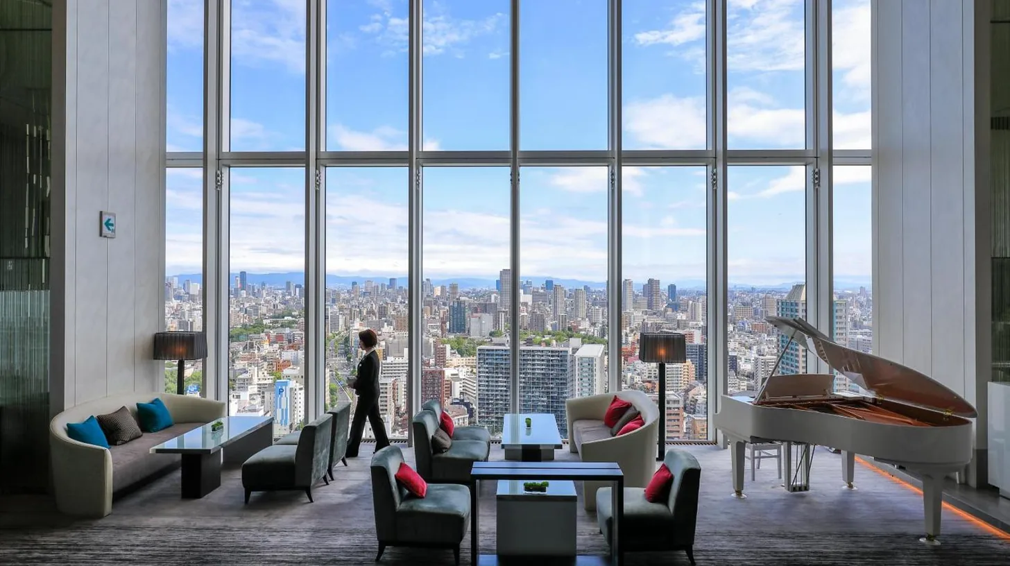 eine Person steht in einem Zimmer mit großem Fenster im Osaka Marriott Miyako Hotel in Osaka