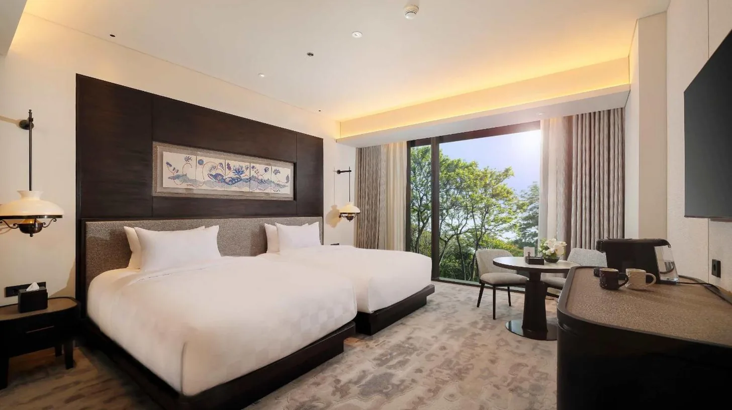 a hotel room with a large bed and a desk at Padma Hotel Semarang in Semarang