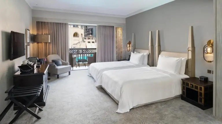 a bedroom with a large white bed and a window at Palace Downtown in Dubai
