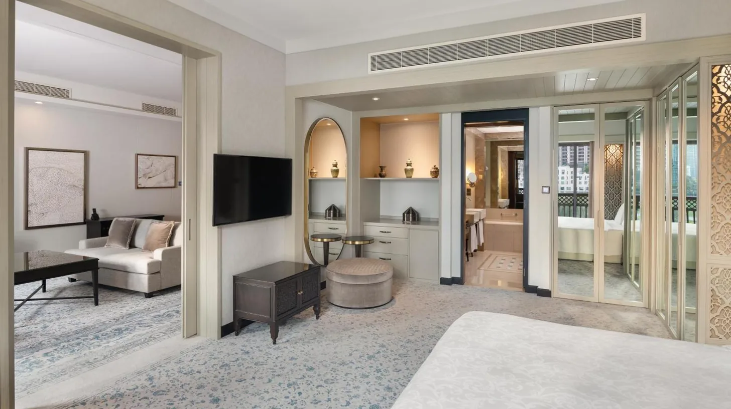 a bedroom with a bed and a living room at Palace Downtown in Dubai