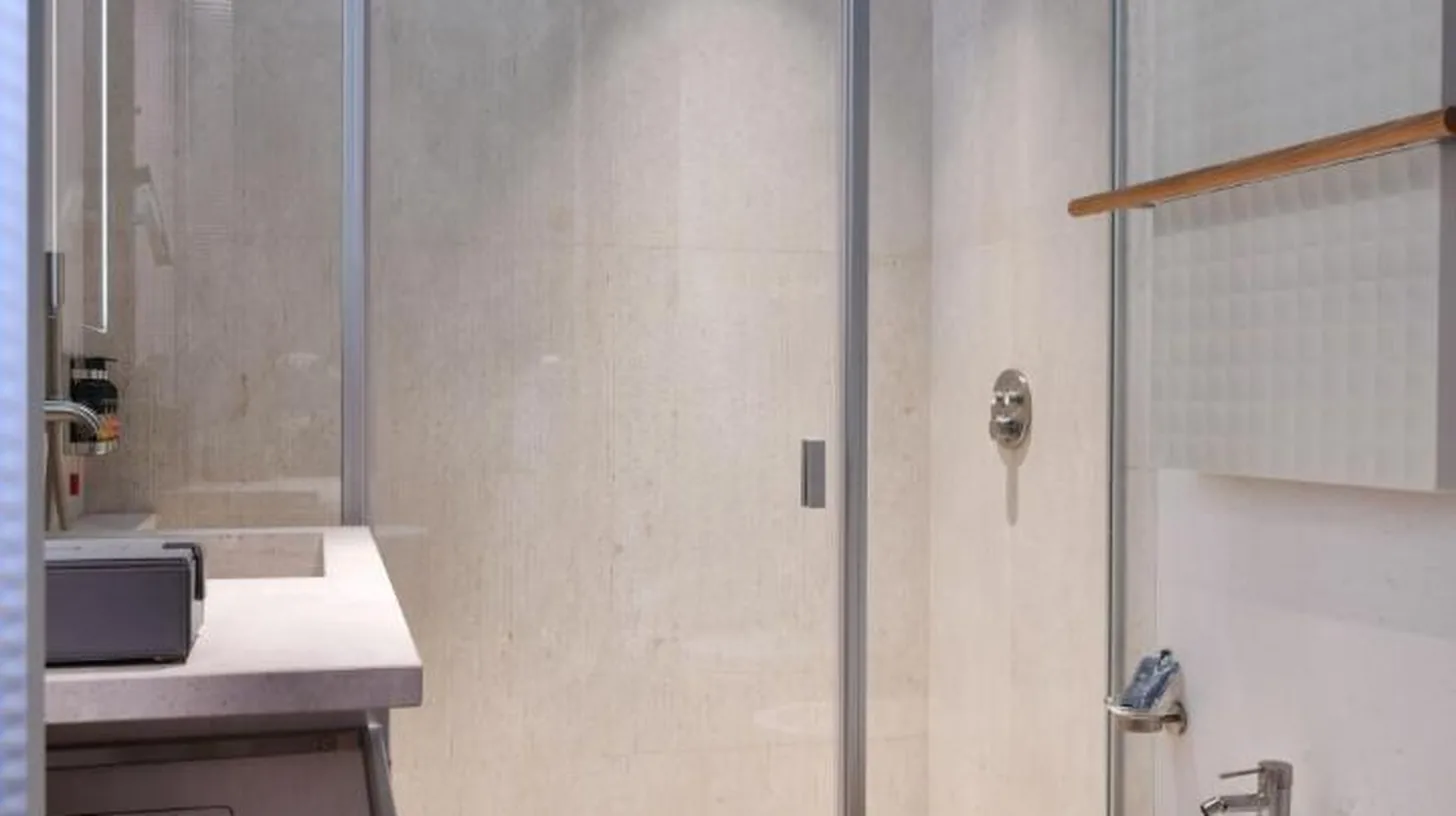 a bathroom with a shower and a toilet and a sink at Palazzo Tirso MGallery Cagliari in Cagliari