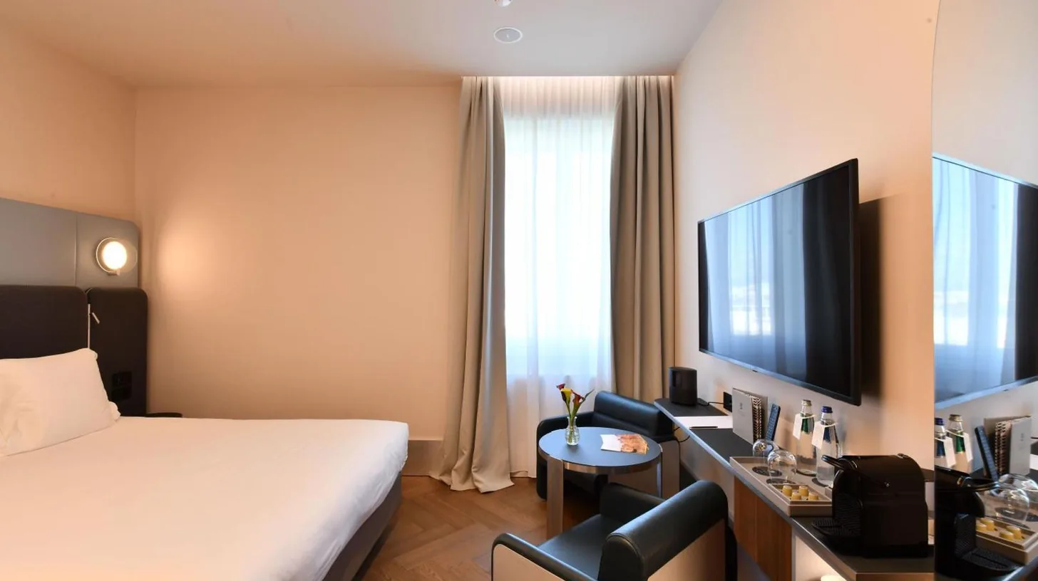 a hotel room with a bed and a desk at Palazzo Tirso MGallery Cagliari in Cagliari