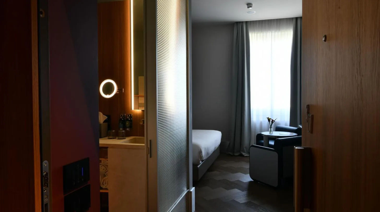 a hotel room with a bed and a window at Palazzo Tirso MGallery Cagliari in Cagliari