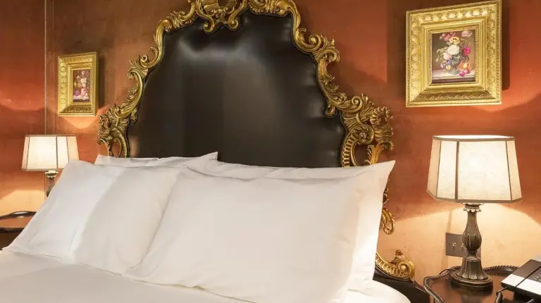 a bedroom with a white bed with a black headboard at Palazzo Venart Luxury Hotel in Venice