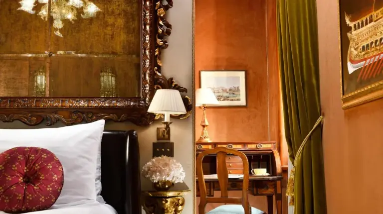 a bedroom with a bed with a lamp and a window at Palazzo Venart Luxury Hotel in Venice