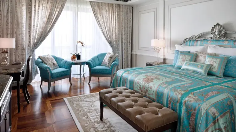 a bedroom with a bed and a living room at Palazzo Versace Dubai in Dubai