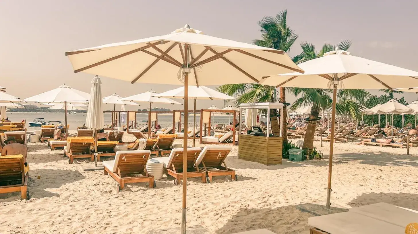 a beach with chairs and umbrellas on the sand at Palm Jumeirah Beach Paradise at Fairmont Residence in Dubai