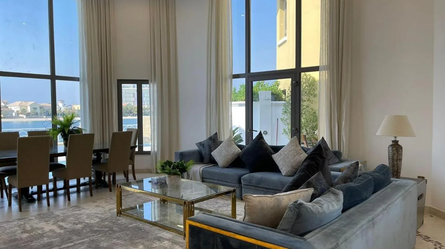ein Wohnzimmer mit einer Couch und einem Tisch in Palm Jumeirah Strandvilla mit privatem Pool, 5 Schlafzimmer & 1 Hausangestelltenzimmer und Strandzugang in Dubai