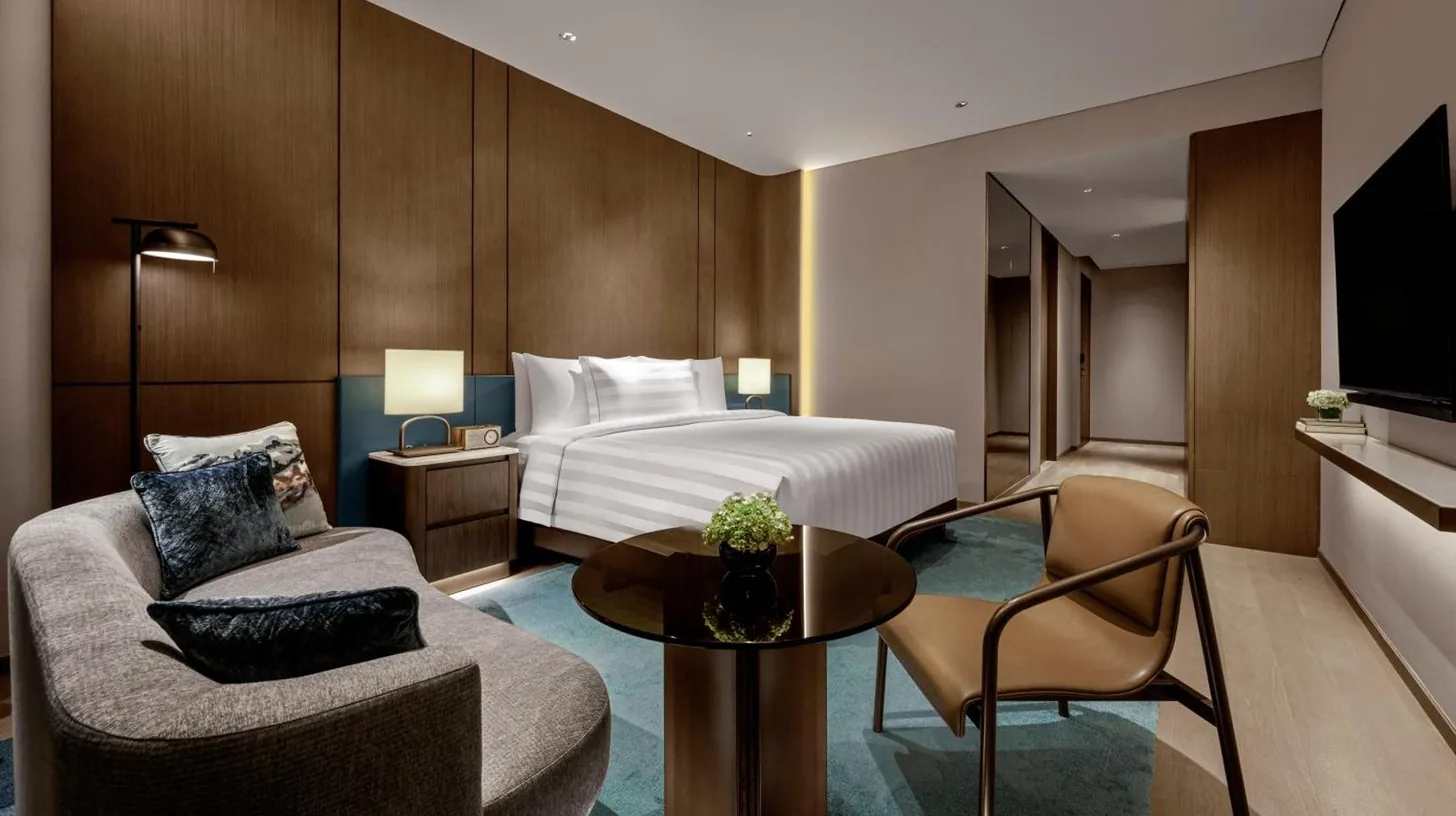 a hotel room with a large bed and a tv at Pan Pacific Jakarta in Jakarta