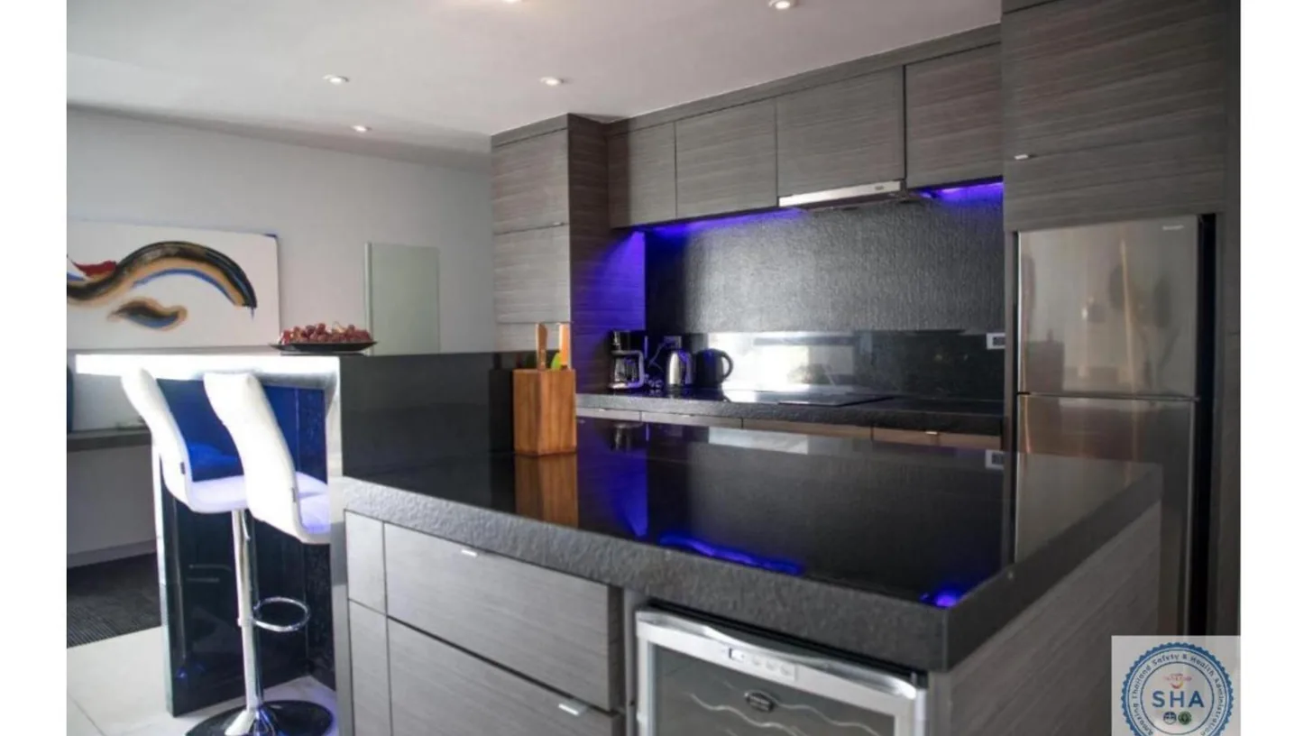 a kitchen with stainless steel appliances and blue lighting at Panorama Samui Residences in Ban Bang Po