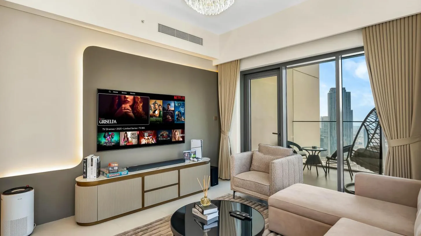 a living room with a couch and a tv at Panoramic Burj Khalifa Views at Burj Royale by Propigo in Dubai