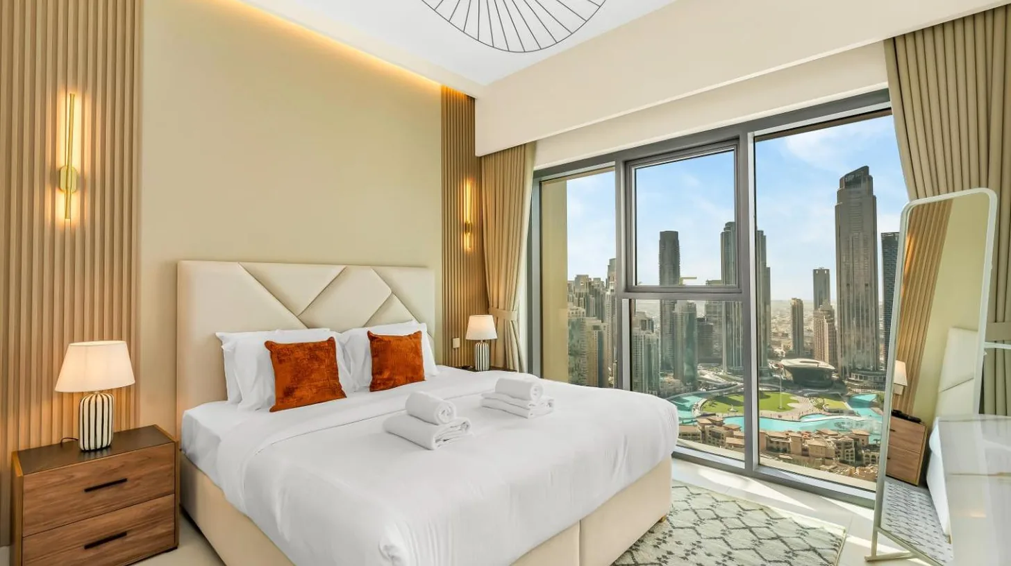 a bedroom with a large bed and a large window at Panoramic Burj Khalifa Views at Burj Royale by Propigo in Dubai
