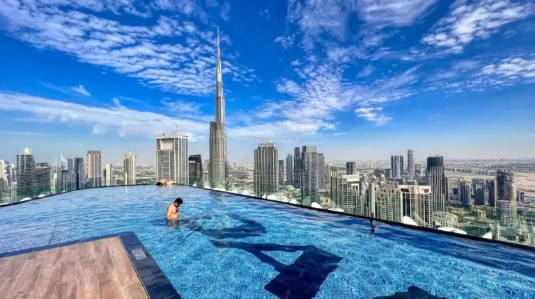 a man in a infinity pool on the top of a skyscraper at Paramount Residences I Access to Infinity Pool in Dubai