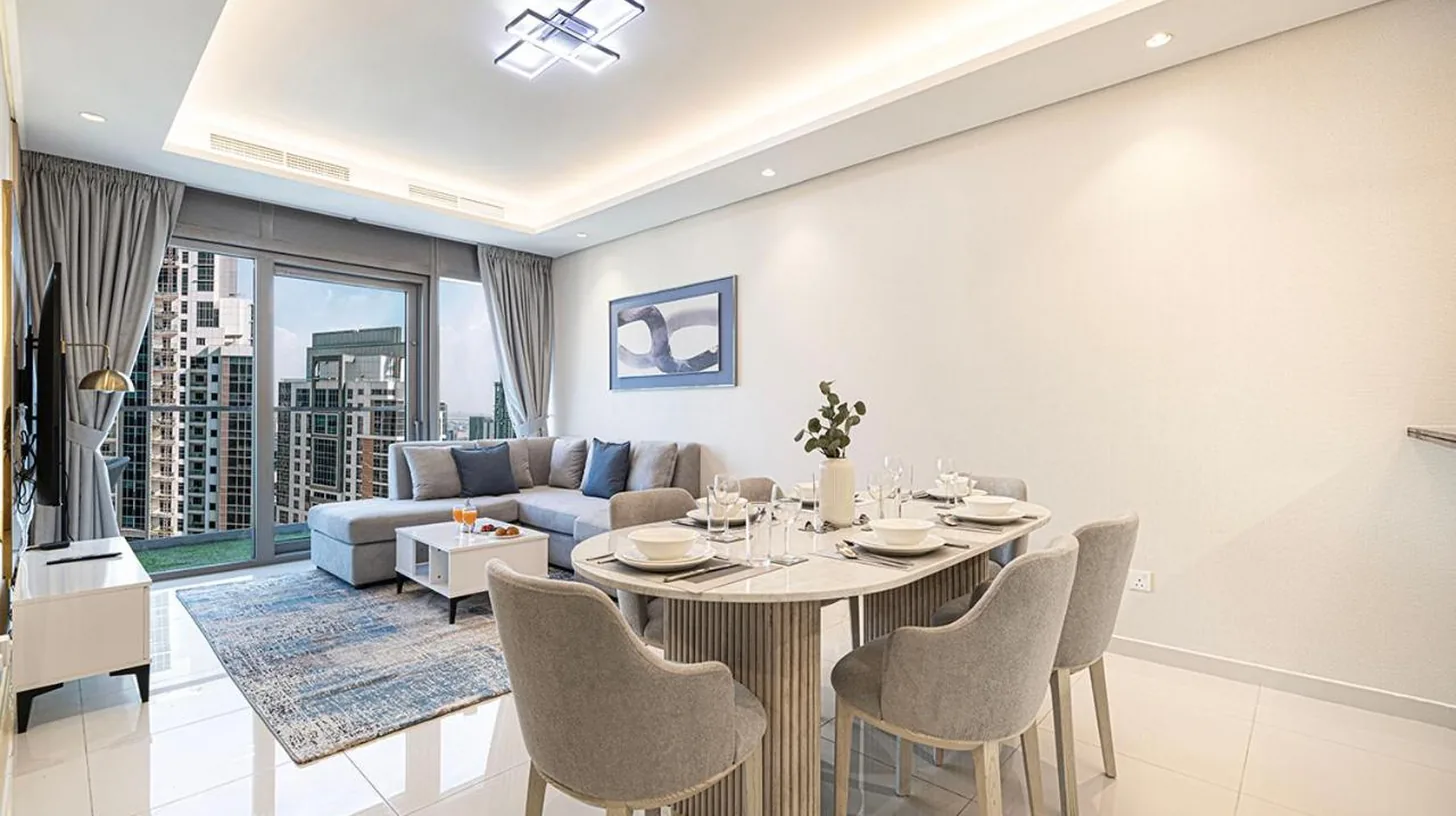 a kitchen with white cabinets and a blue table at Paramount Residences I Access to Infinity Pool in Dubai