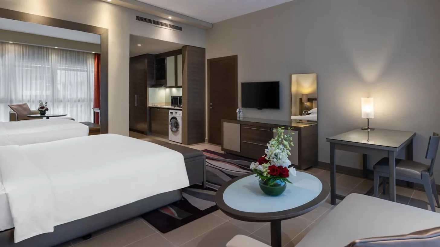 une chambre d'hôtel avec un grand lit et un bureau à Park Arjaan by Rotana