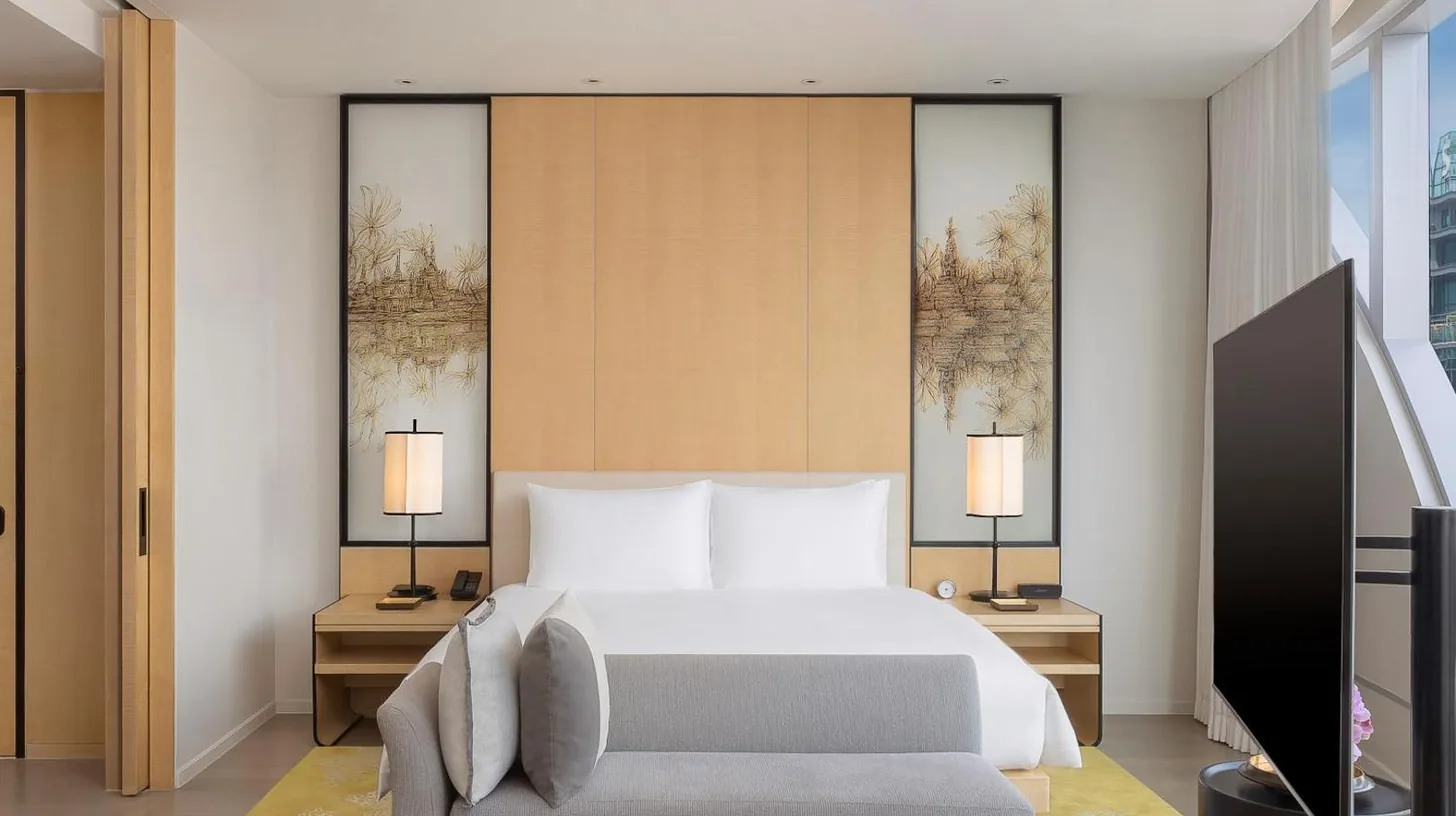 a bedroom with a bed and a couch and a tv at Park Hyatt Bangkok in Bangkok