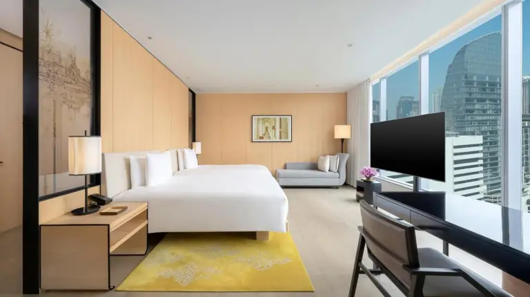 a hotel room with a bed and a tv at Park Hyatt Bangkok in Bangkok