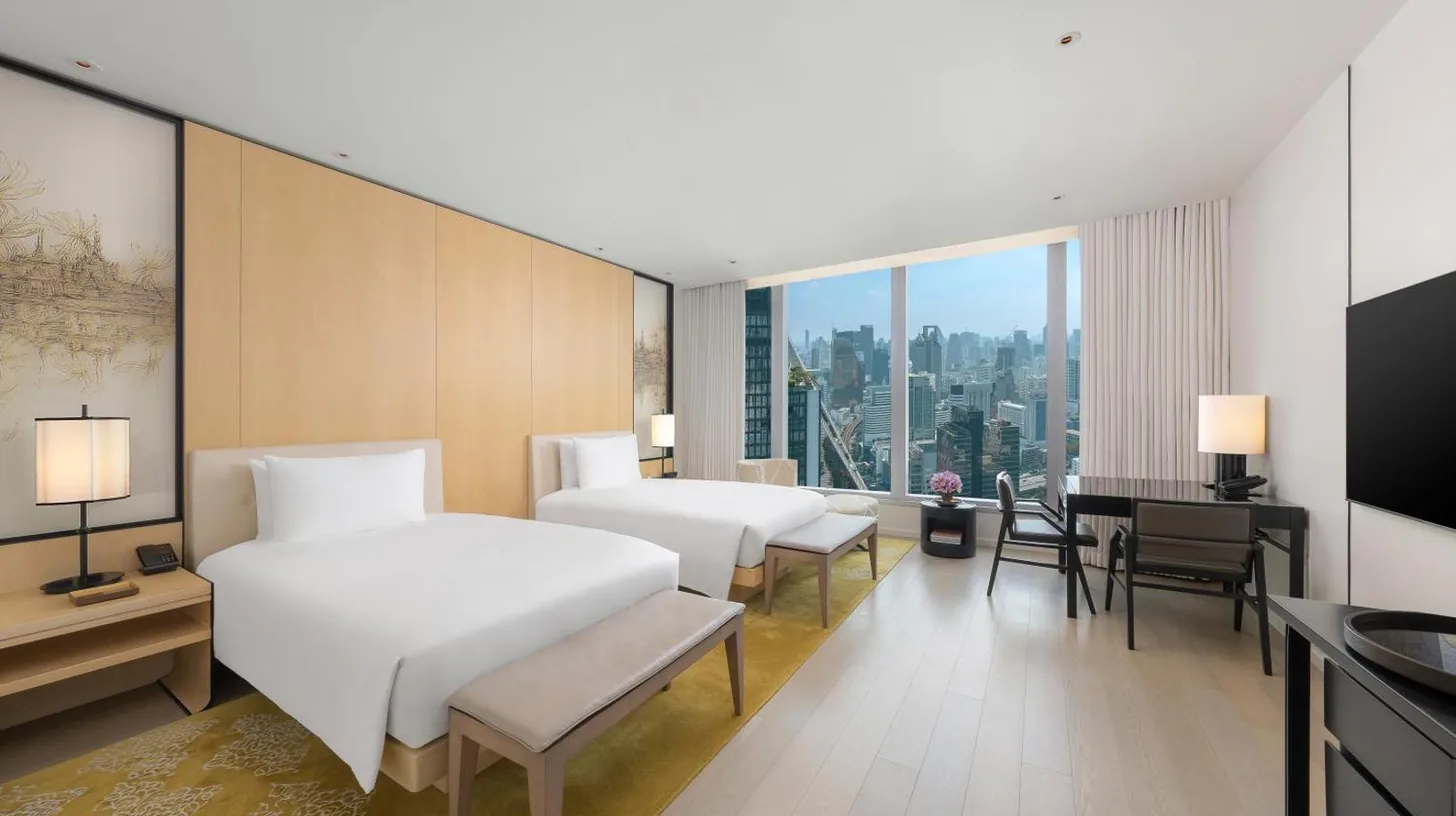 a hotel room with two beds and a desk at Park Hyatt Bangkok in Bangkok