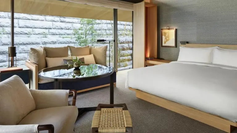 a bedroom with a bed and a couch and a table at Park Hyatt Kyoto in Kyoto