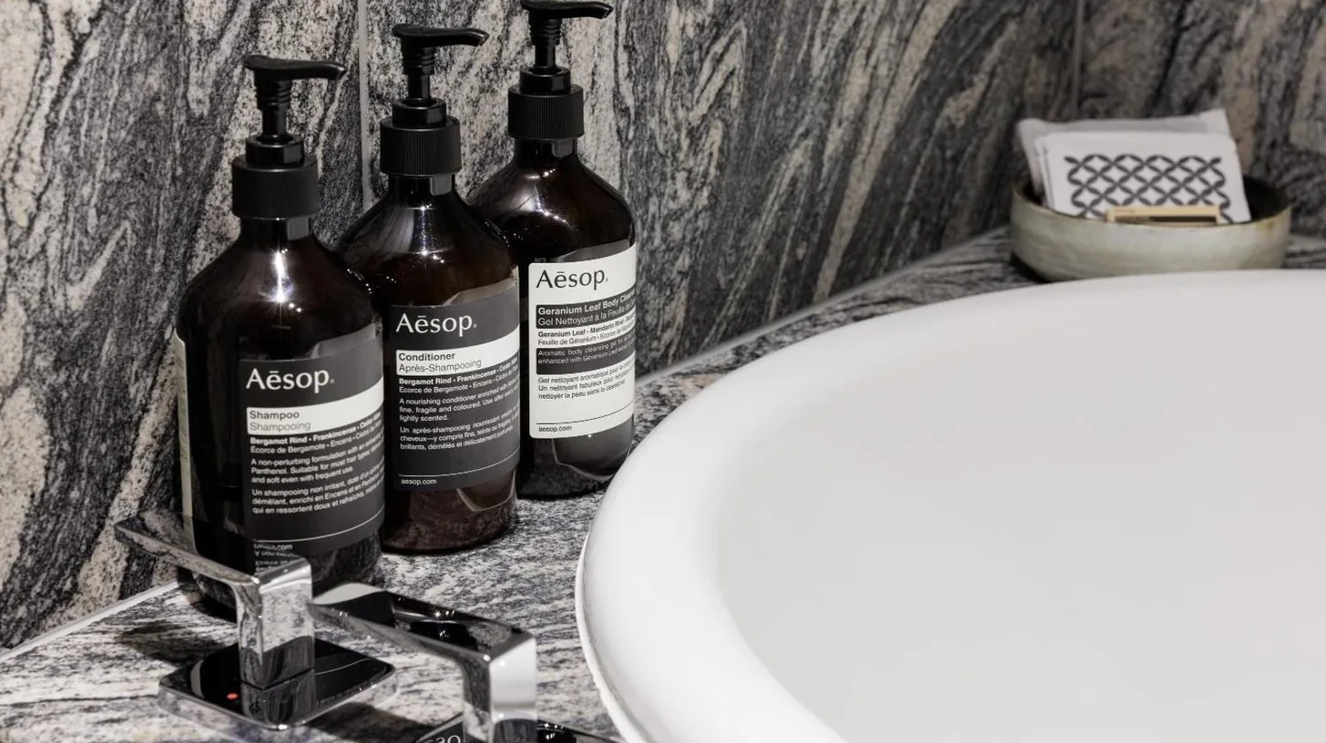 three bottles of alcohol are sitting on a bathroom sink at Park Hyatt Kyoto in Kyoto