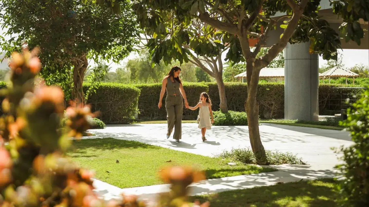 a woman and a little girl walking down a sidewalk at Park Rotana Abu Dhabi in Abu Dhabi