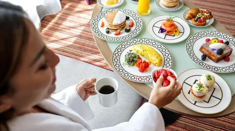 a woman sitting at a table with plates of food at Park Rotana Abu Dhabi in Abu Dhabi