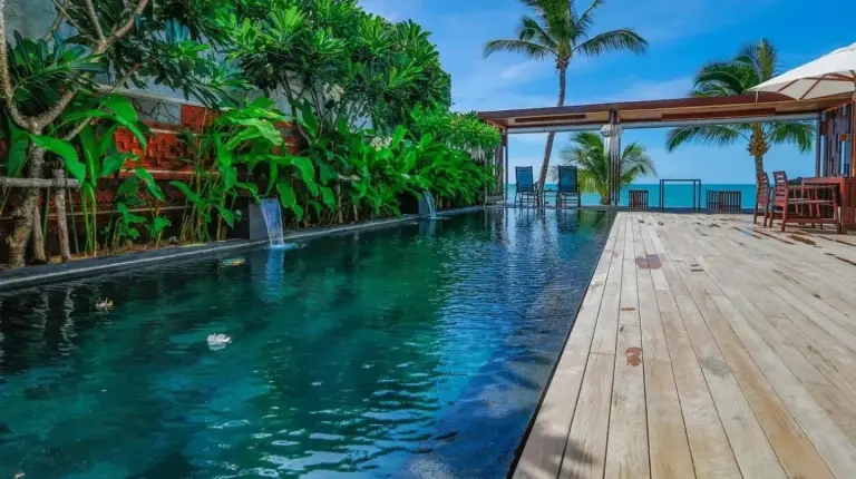 a pool at a resort with a wooden deck at Pavilion Pool Residence Samui - SHA Extra Plus in Lamai
