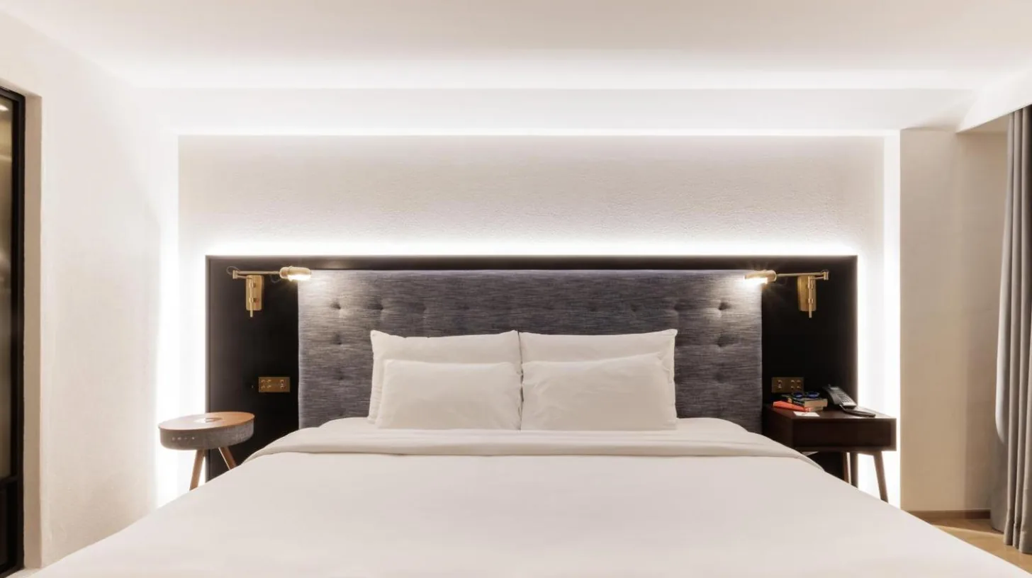 a large bed in a hotel room with a large window at Public House Bangkok