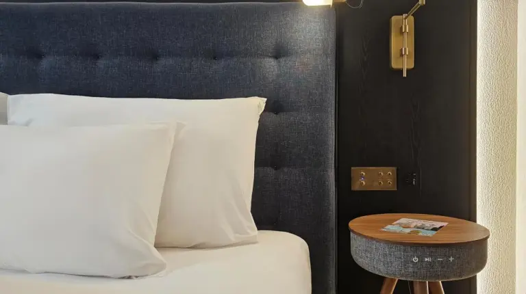 a hotel room with a large bed and a red chair at Public House Bangkok