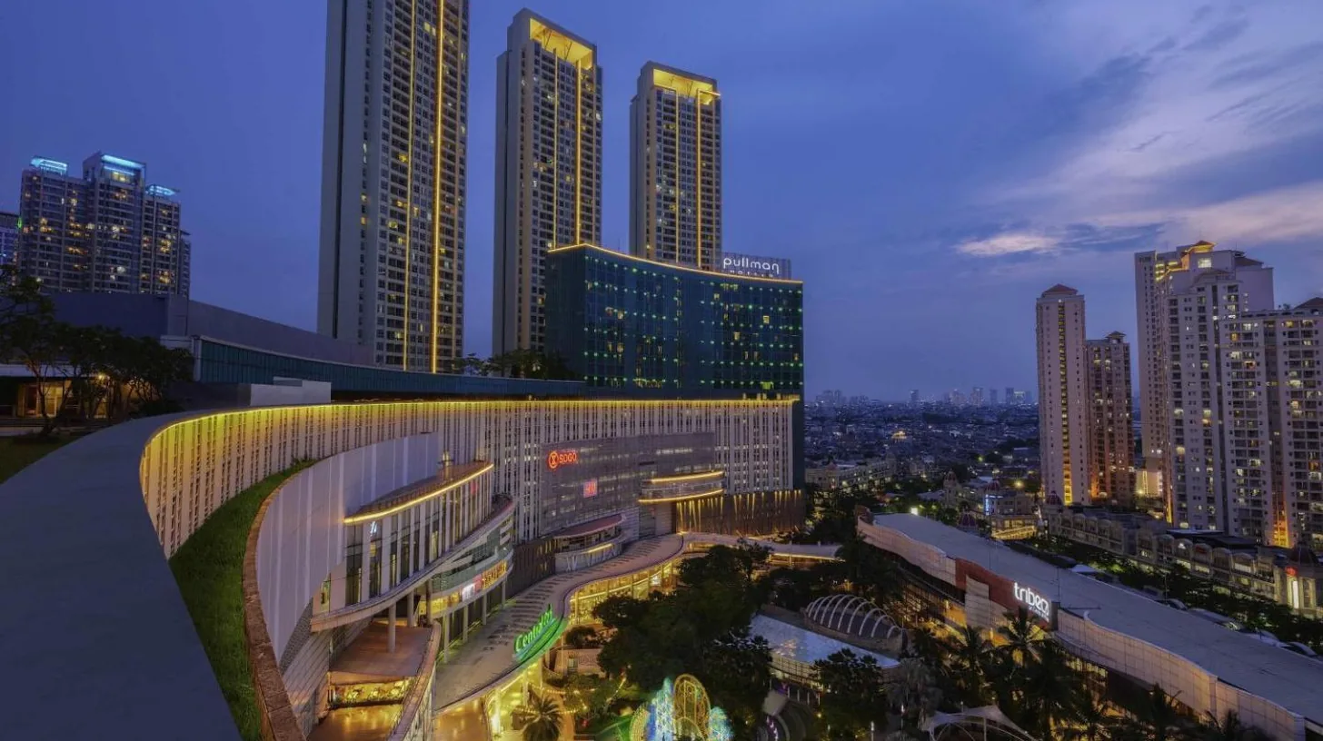 a view of a city at night with tall buildings at Pullman Jakarta Central Park in Jakarta