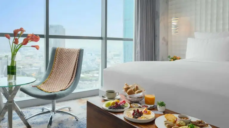 a hotel room with a tray of food on a table at Pullman Jakarta Central Park in Jakarta