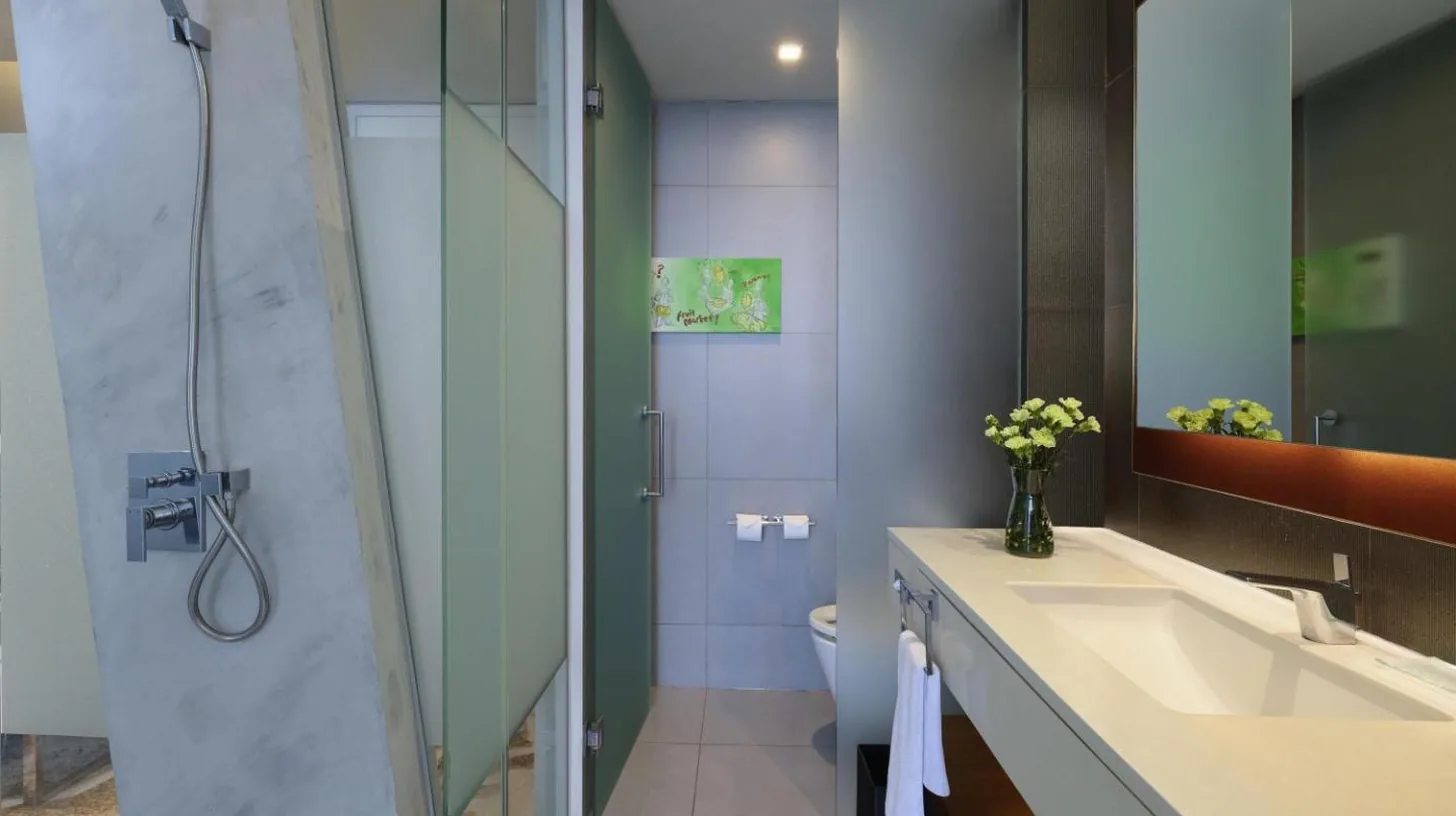 a bathroom with a sink and a toilet and a shower at Pullman Jakarta Central Park in Jakarta