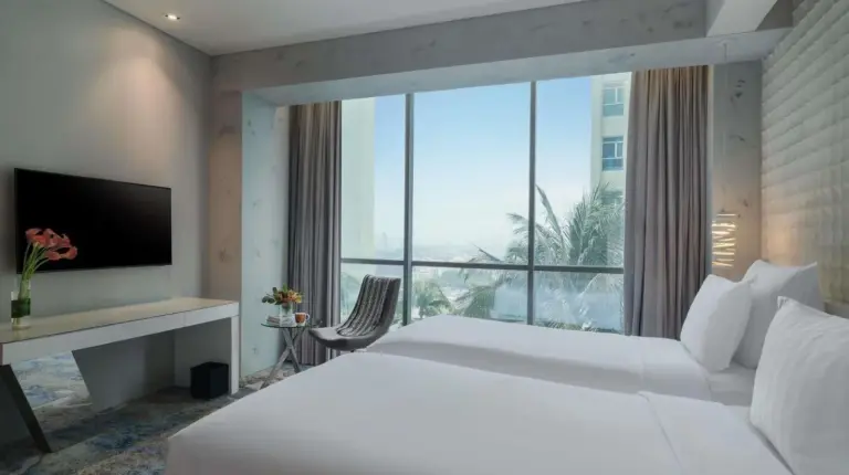 a bedroom with a large white bed in it at Pullman Jakarta Central Park in Jakarta
