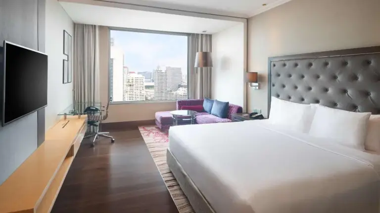 a hotel room with a bed and a large window at Radisson Blu Plaza Bangkok in Bangkok