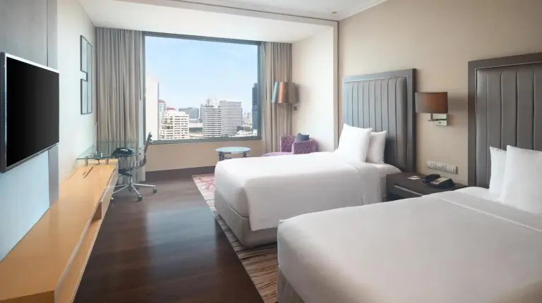 a hotel room with two beds and a large window at Radisson Blu Plaza Bangkok in Bangkok
