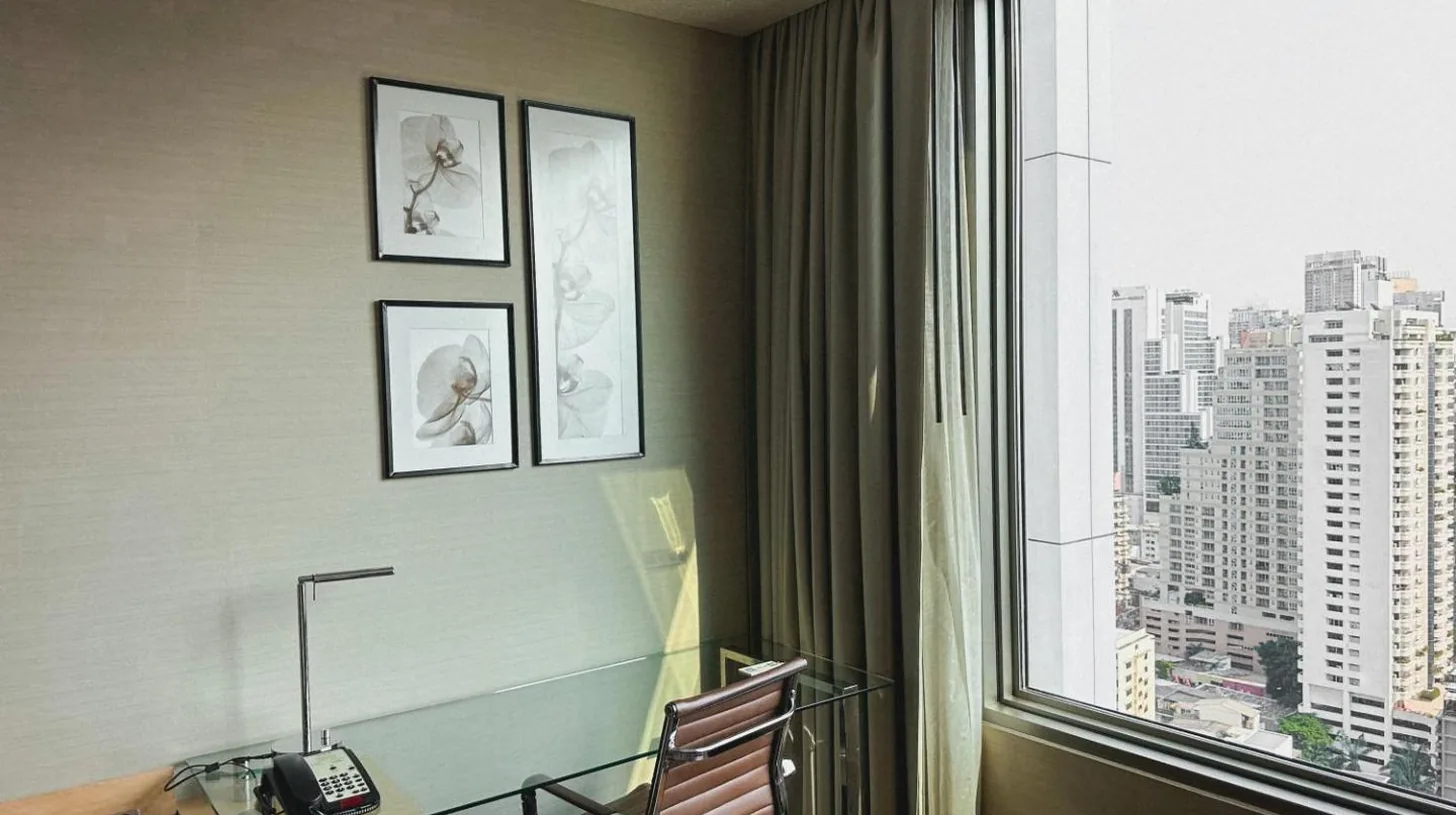 a hotel room with a chair and a large window at Radisson Blu Plaza Bangkok in Bangkok