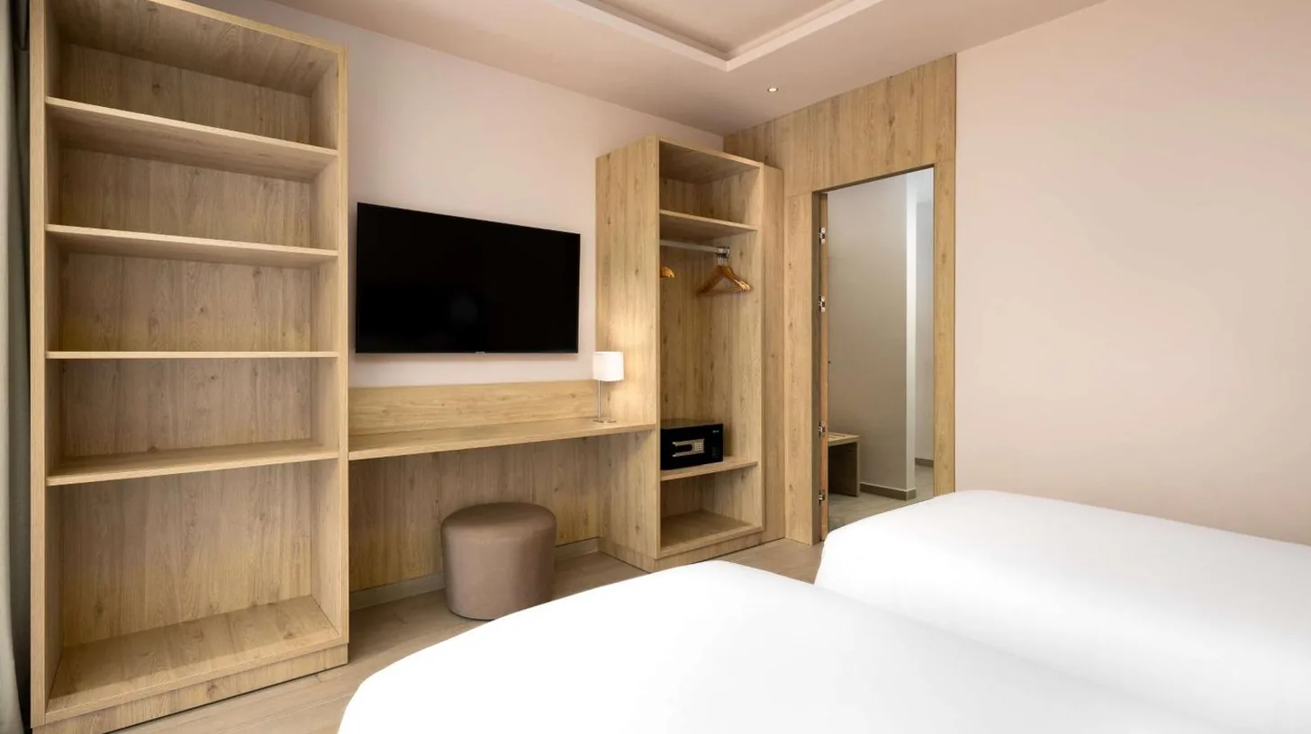 a bedroom with a bed and a tv and shelves at Radisson Blu Resort Al Hoceima in Al Hoceïma