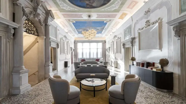 a lobby with chairs and a table and a ceiling at Radisson Collection Hotel