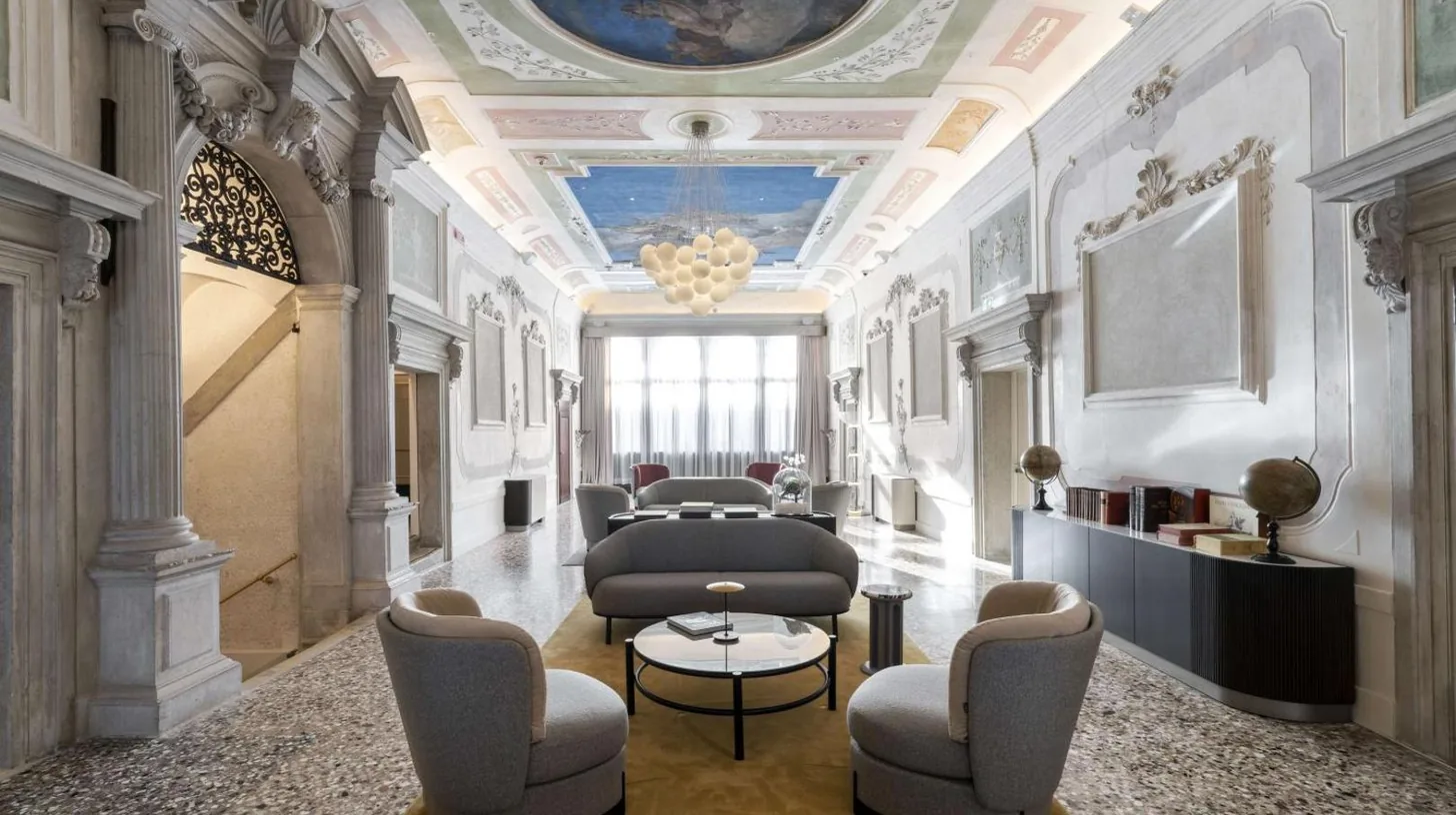 a lobby with chairs and a table and a ceiling at Radisson Collection Hotel