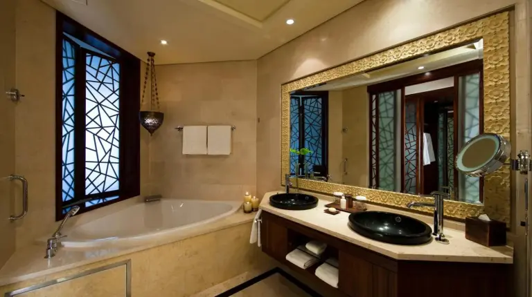 a living room with a bed and a desk in a room at Raffles Dubai in Dubai