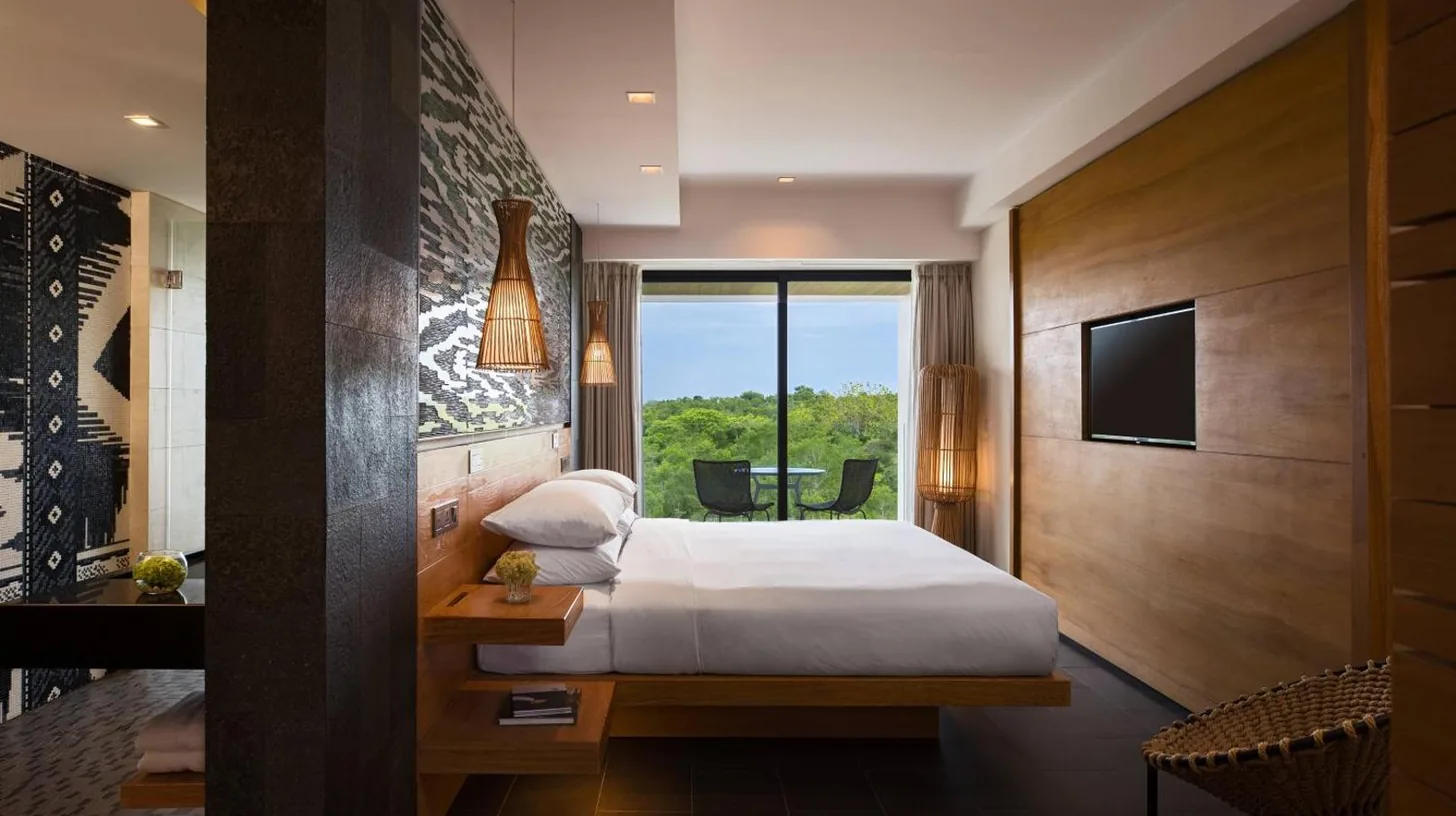 Une chambre d'hôtel avec un lit et une télévision au Renaissance Bali Uluwatu Resort & Spa à Uluwatu