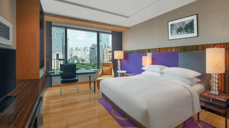 a bedroom with a large white bed and a desk at Renaissance Bangkok Ratchaprasong Hotel in Bangkok
