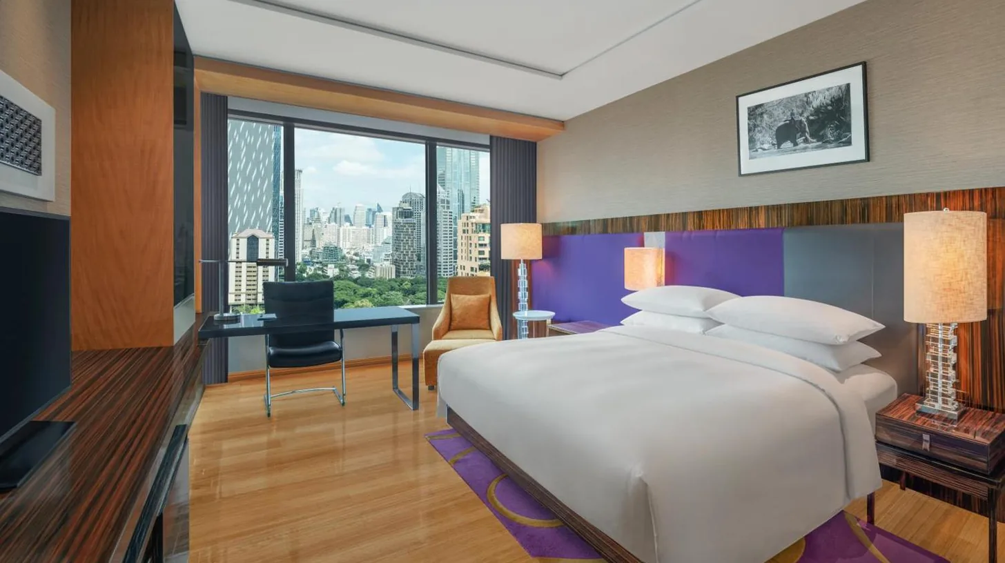 a bedroom with a large white bed and a desk at Renaissance Bangkok Ratchaprasong Hotel in Bangkok