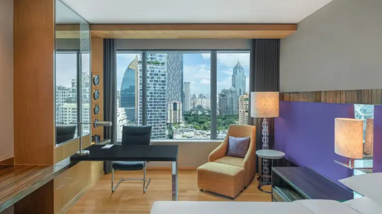 a bedroom with a bed and a desk and a chair at Renaissance Bangkok Ratchaprasong Hotel in Bangkok