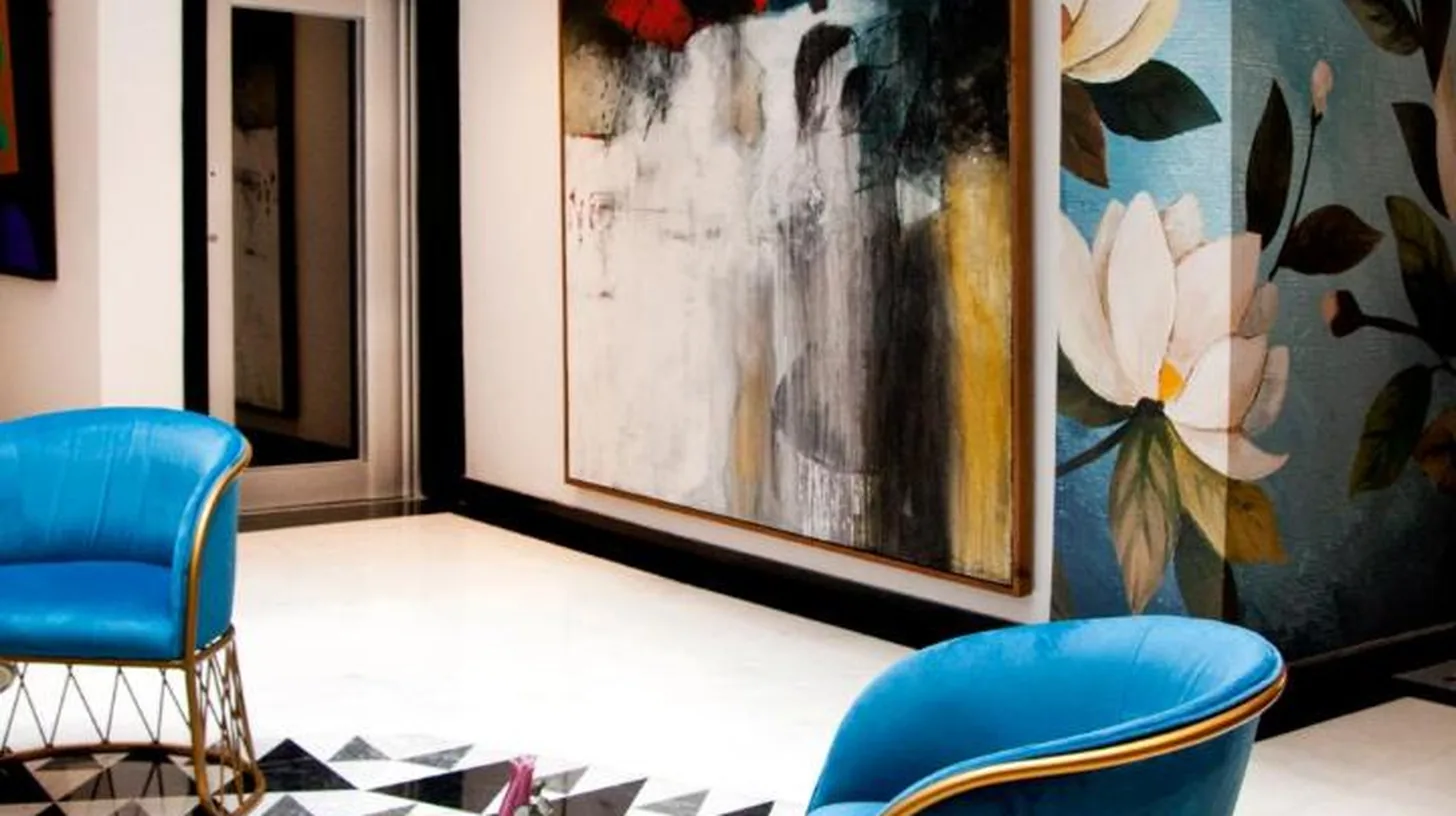 a lobby with blue chairs and a painting at Riad Dar Saba - Saba's House in Tangier