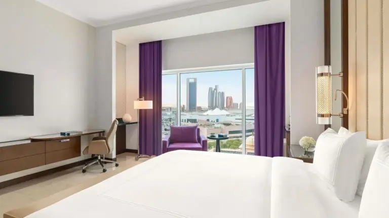 a hotel room with a large bed and a window at Rixos Marina Abu Dhabi in Abu Dhabi