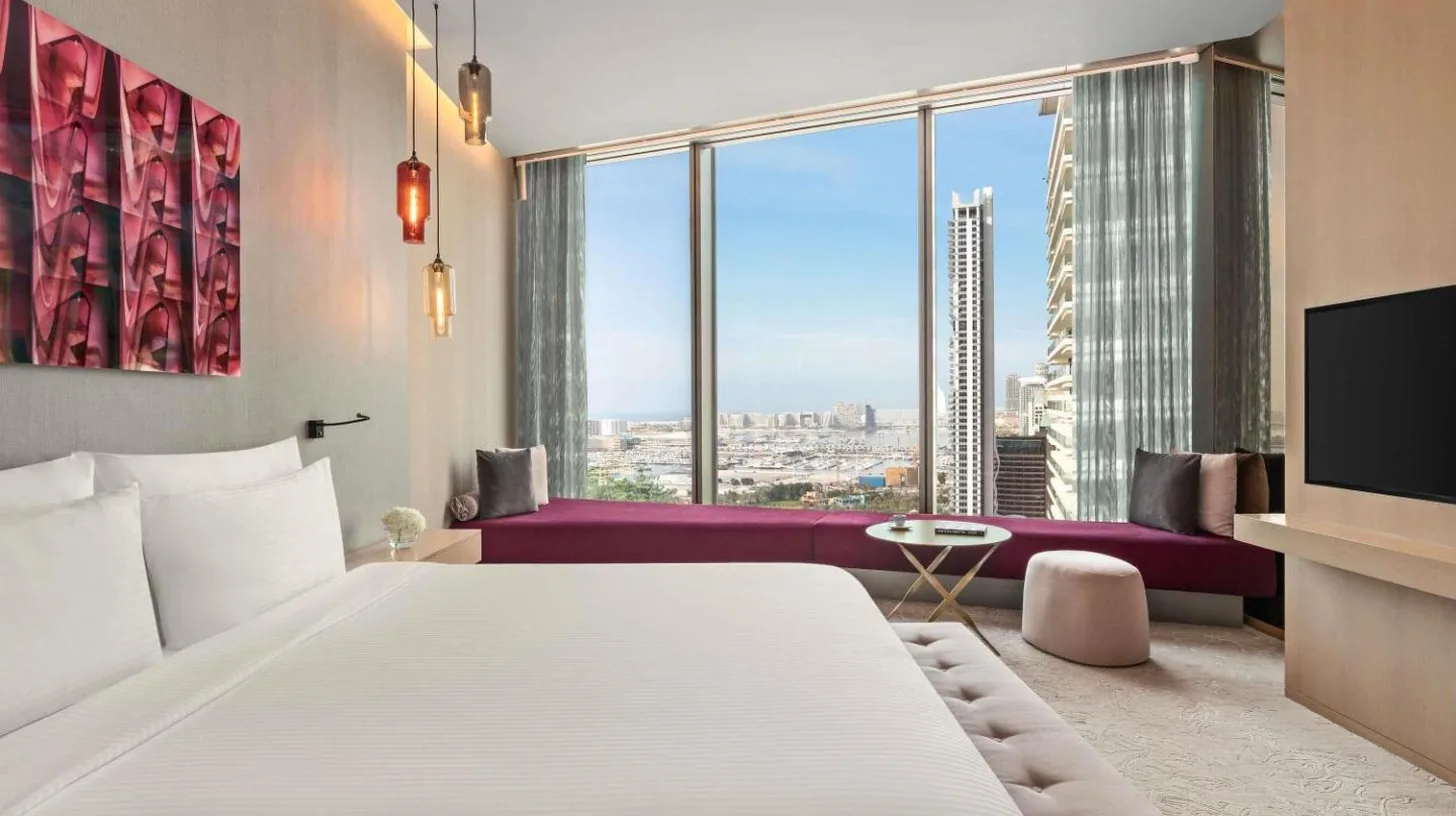 a bedroom with a large white bed and a large window at Rixos Premium Dubai JBR in Dubai