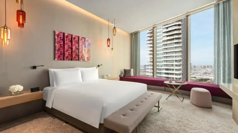 a hotel room with a large white bed and a large window at Rixos Premium Dubai JBR in Dubai